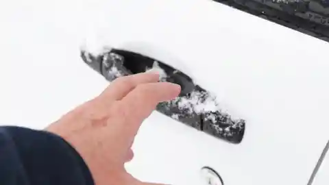Metiendo la mano en su coche